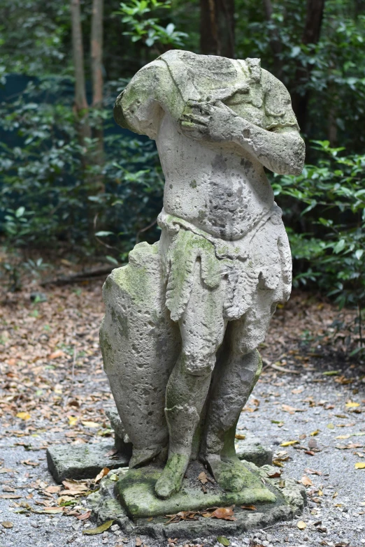 a stone statue of a monkey is in the park