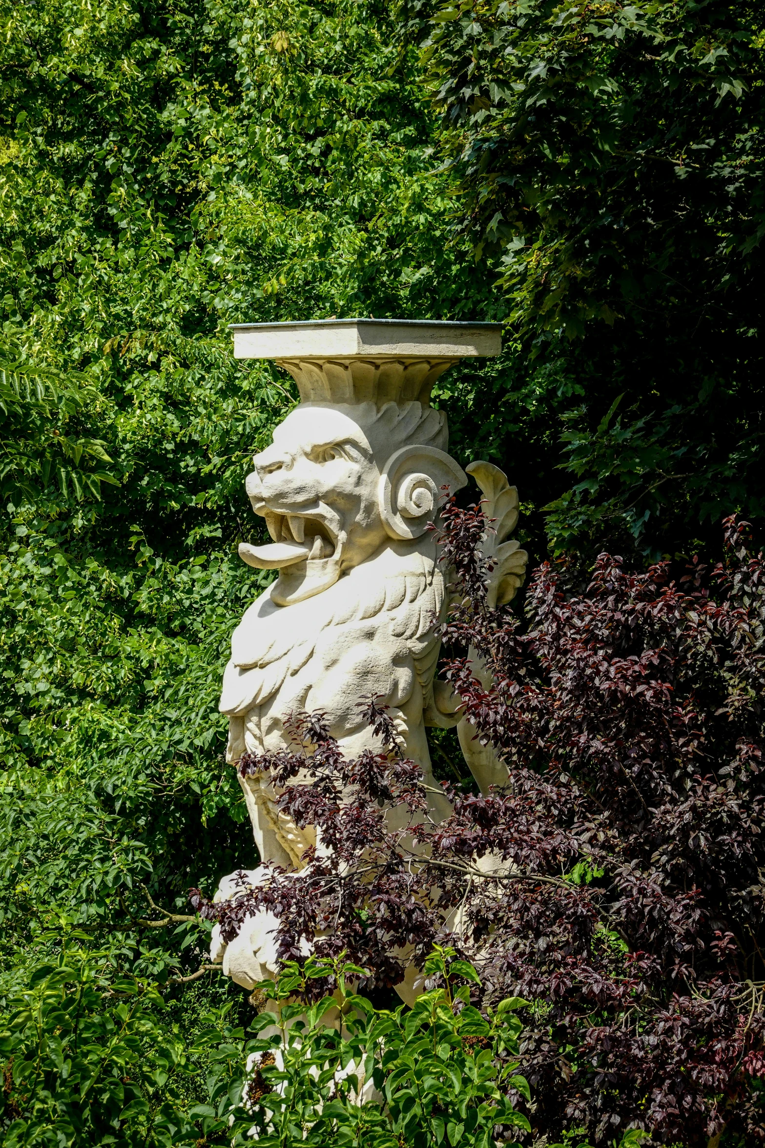 the large statue in the garden is sculpted like a dog