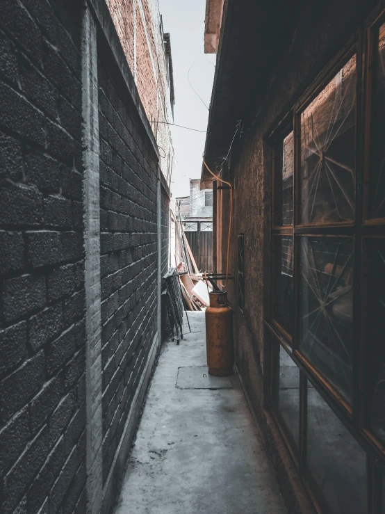 a walkway lined with wood buildings with several windows