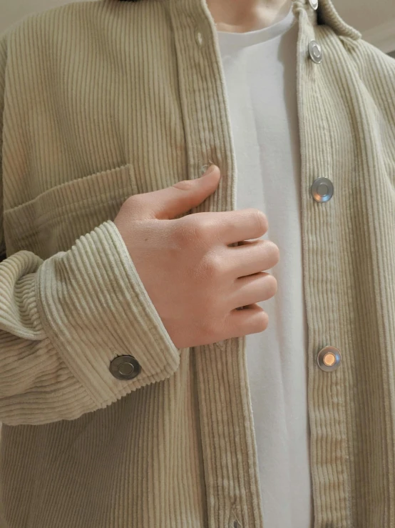 a person's hand in front of a white shirt