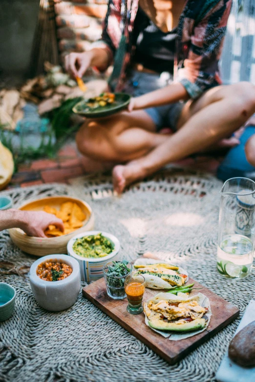 people are sitting outside with bowls and plates