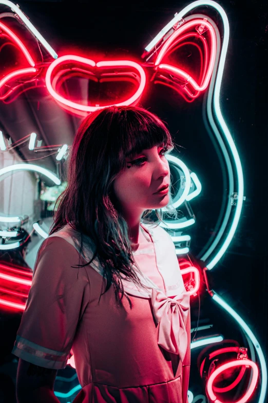 woman in pink dress standing in front of colorful neon neon letters