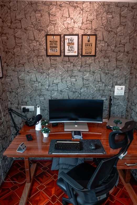 a computer desk with a black chair and some pictures