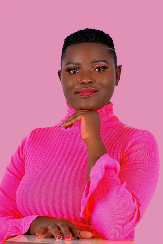 a black woman with her chin up, in a pink shirt, poses for a portrait