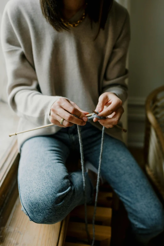 a person is doing soing with yarn and needles