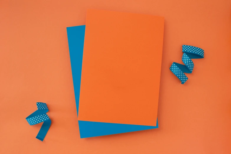 a orange paper with blue polka doted tape sitting on top of it