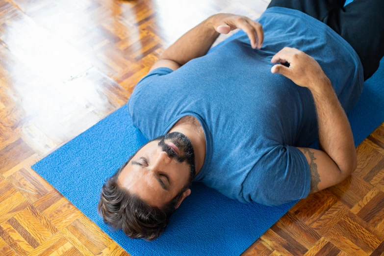 a man is sitting on the floor doing some gymnastics