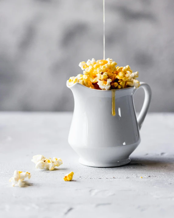 popcorn pours into a pitcher with orange zest