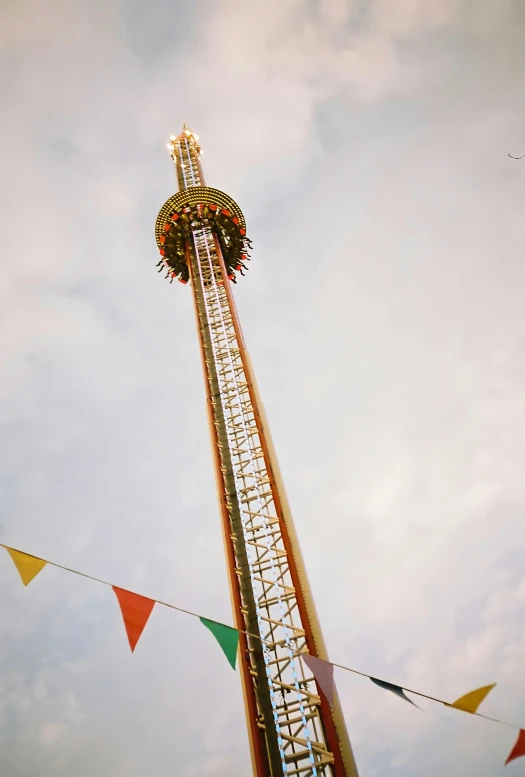 a fairground with flags and ferris wheel in the background