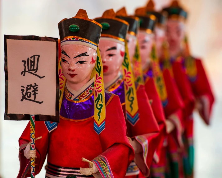 a row of chinese dolls with costumes