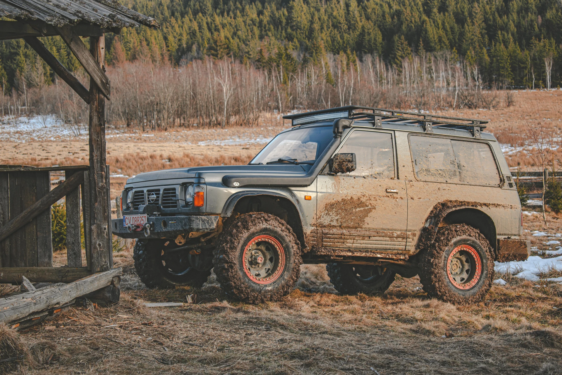 the off - road vehicle has been rusted and is parked in the dirt