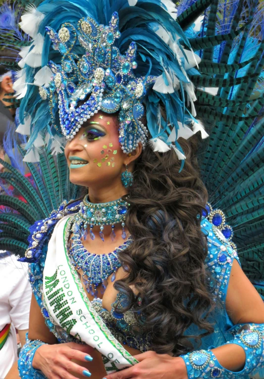 a woman wearing blue costume with feathers on the head