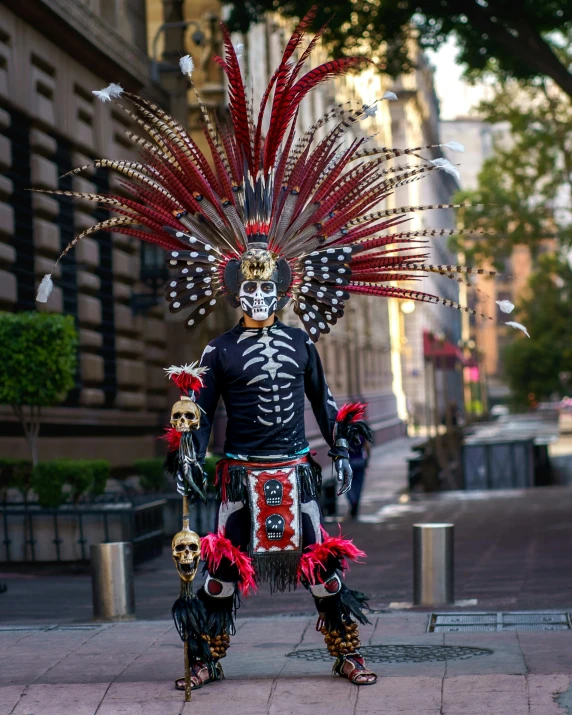 the skeleton stands dressed in traditional costume, elaborate headgear and costume