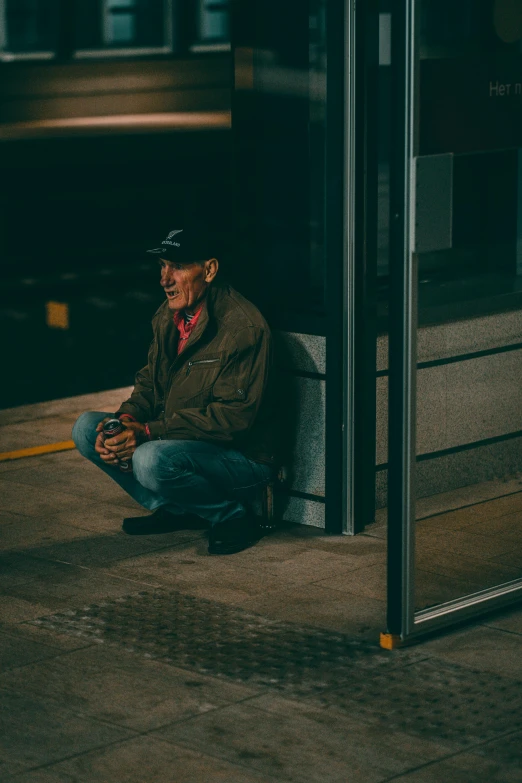 a man sits on the sidewalk in front of a door