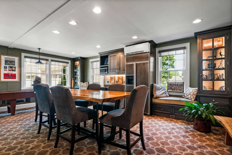 a dining area with a bench and many windows