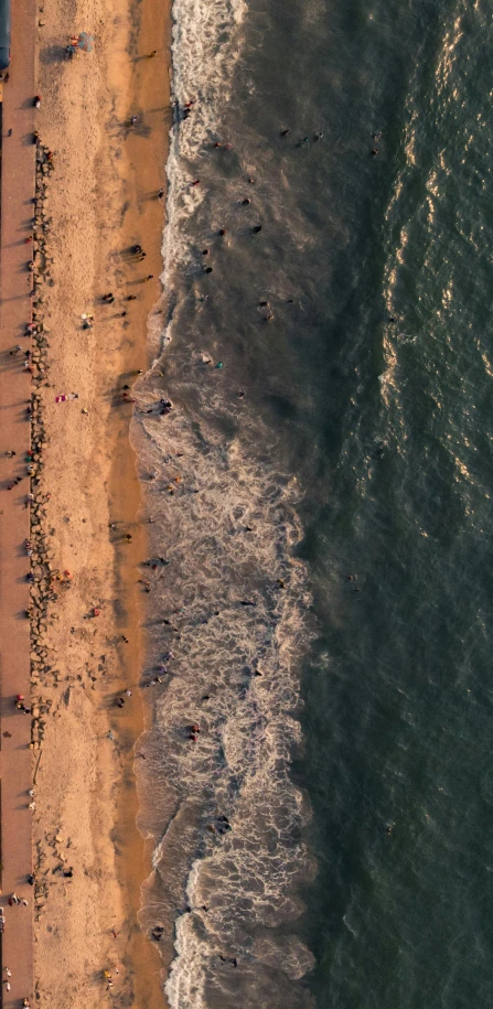 a beach next to the ocean with people standing on it