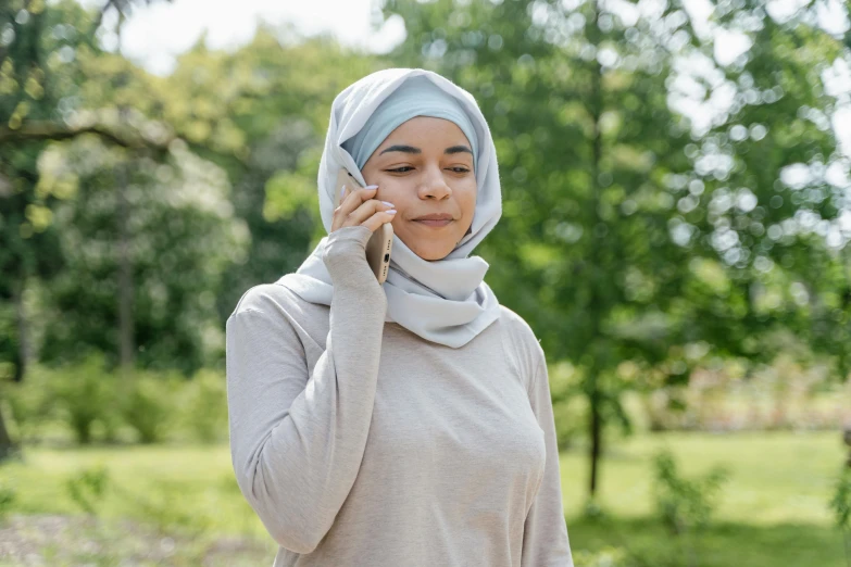 a woman wearing a headscarf and talking on the phone