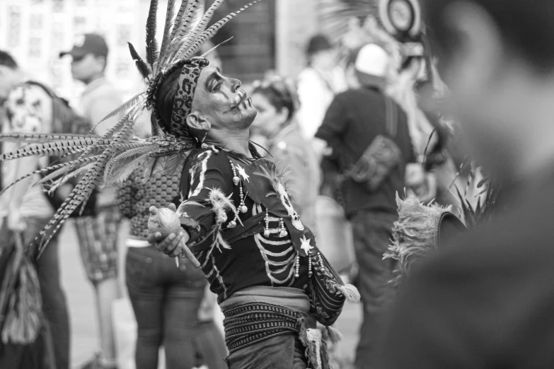 a man dressed up for a carnival walking down the street