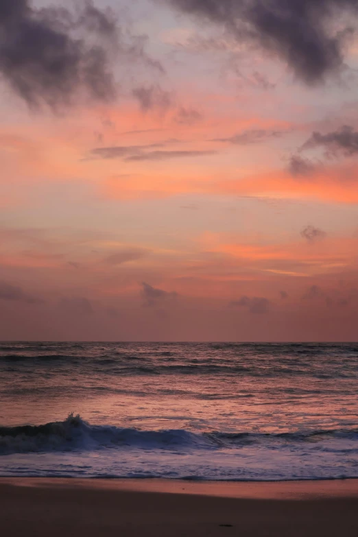 ocean waves at dusk with red sky above