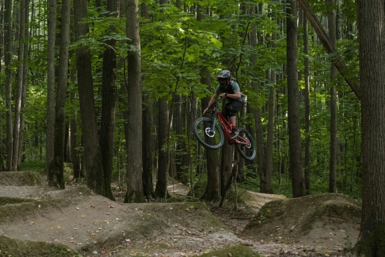 a person in a helmet jumping a bike over some dirt