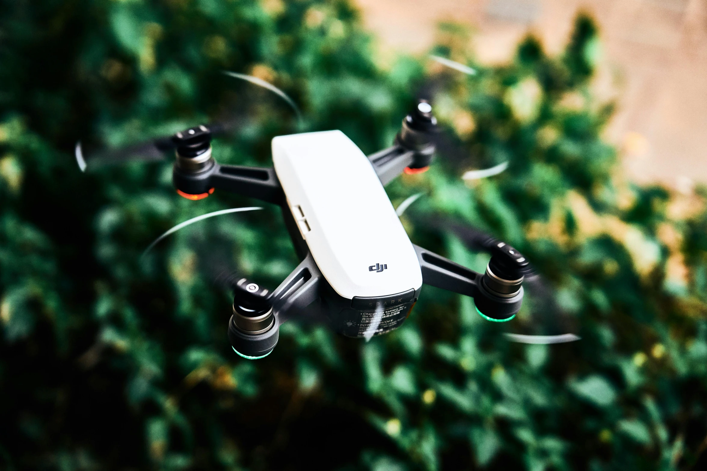 a remote controlled quadcopter flying over a bunch of trees