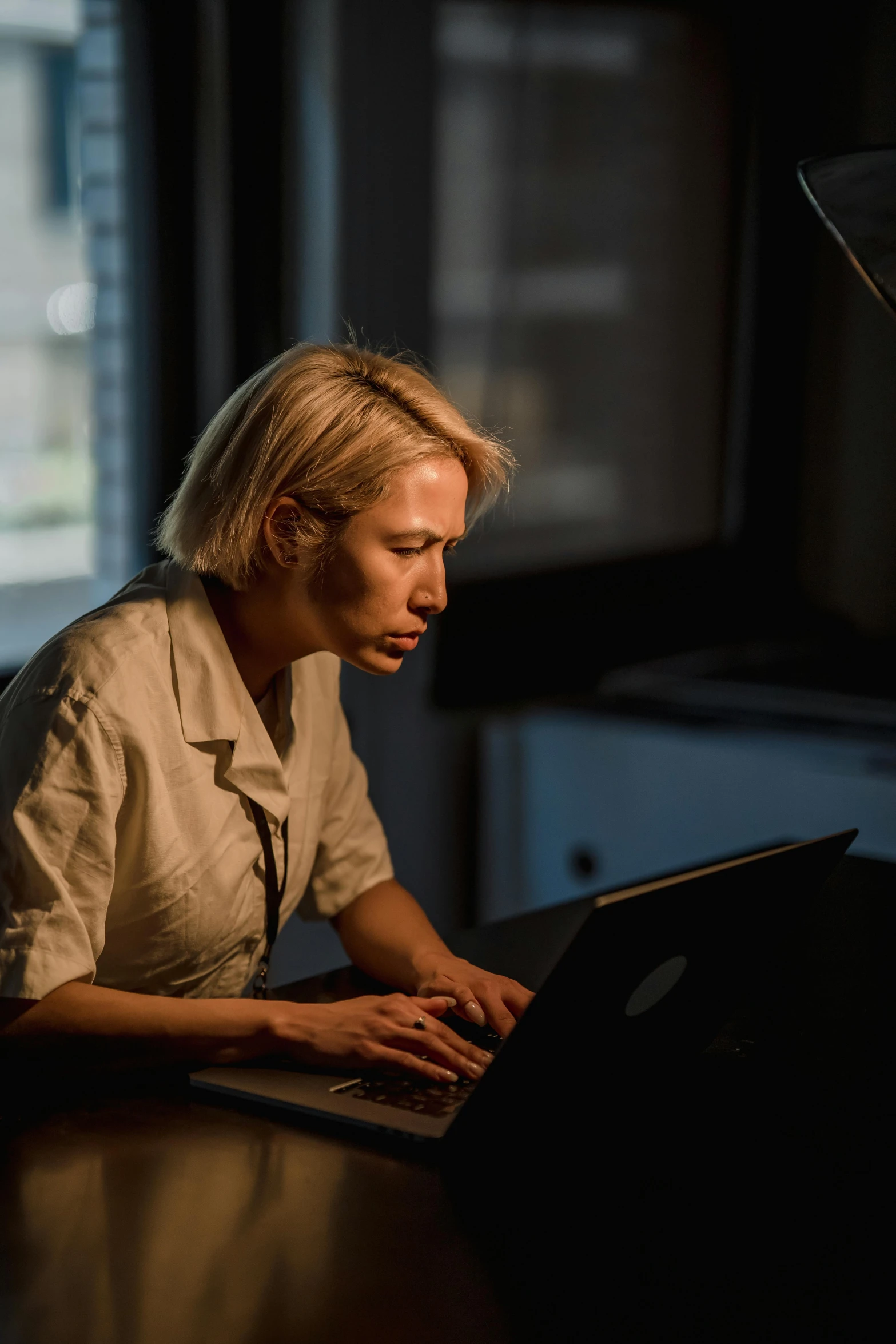 a person in a beige jacket on a laptop