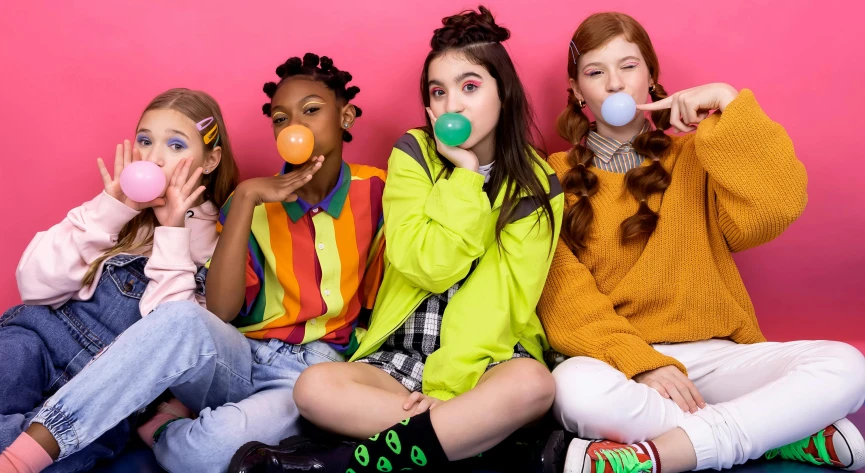 three girls with clown noses are sitting down