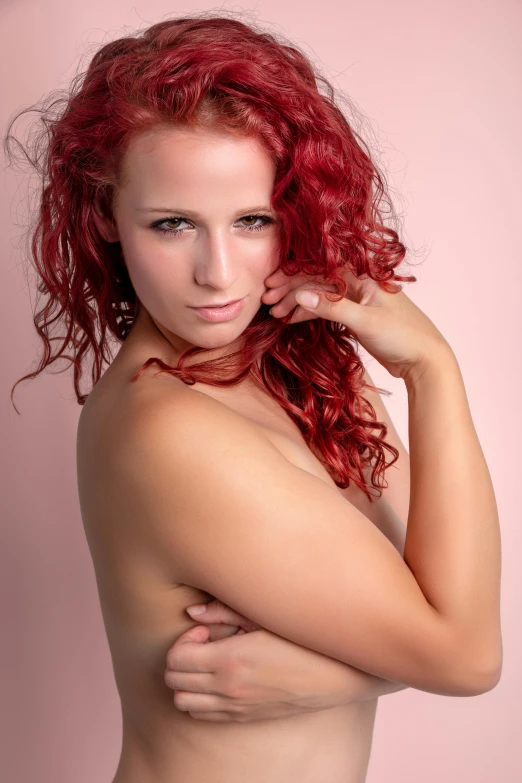 a  redhead woman with her arms folded in a pose