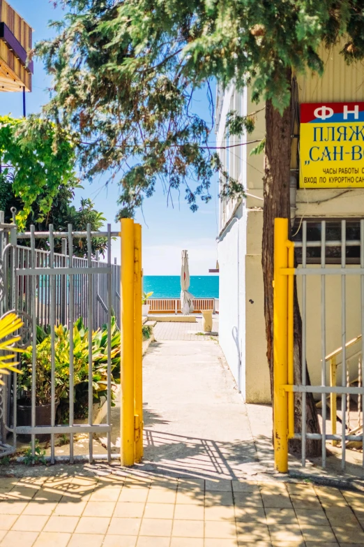 there are two yellow gates leading to a beach