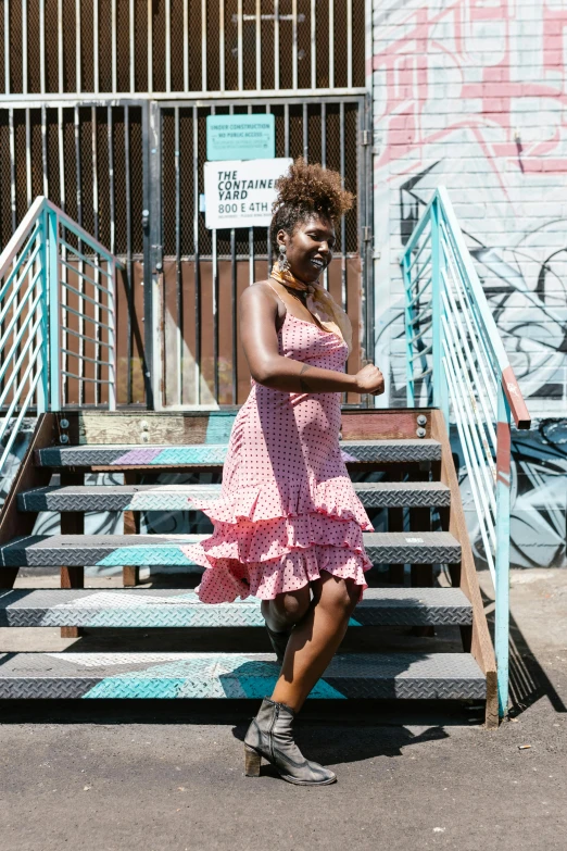 a woman poses with her feet crossed on a set of stairs