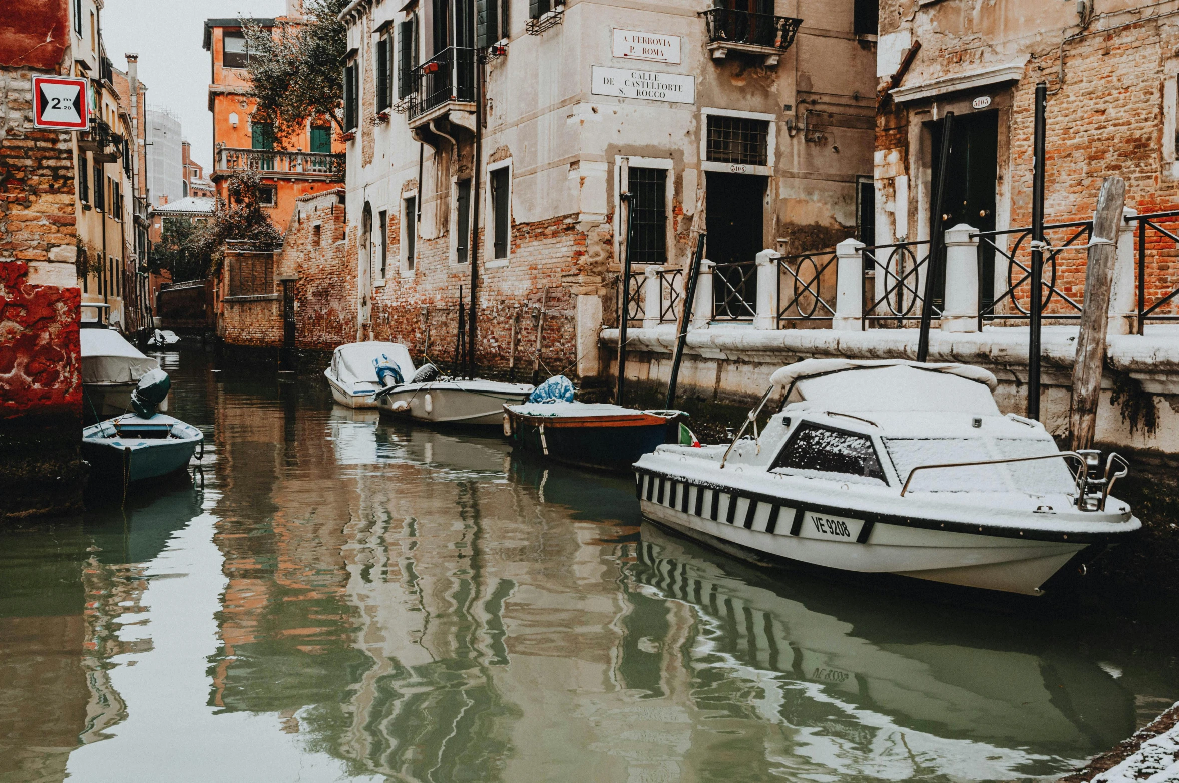 several boats sit docked outside of an apartment complex