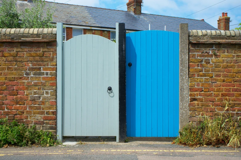 a blue door and a brick wall with a fence