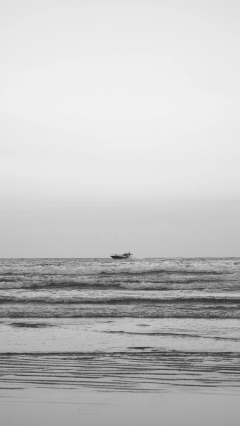 a small boat floating on top of the ocean in front of a boat