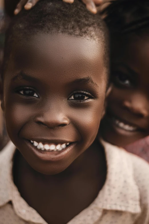 an african child smiling with two other children in background