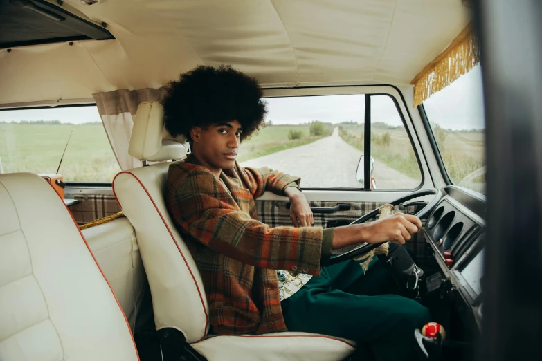 a woman driving a bus with a big afro hair style