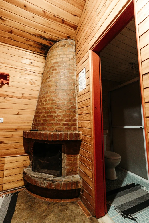 a stone fire place is in the corner of a bathroom