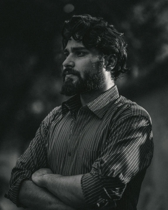 black and white pograph of a man leaning forward with his arms crossed