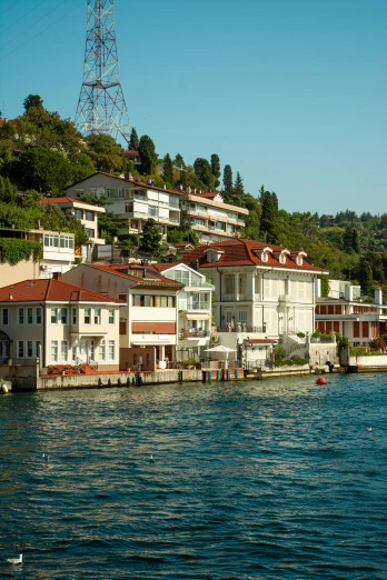 a body of water with houses on a hill near by