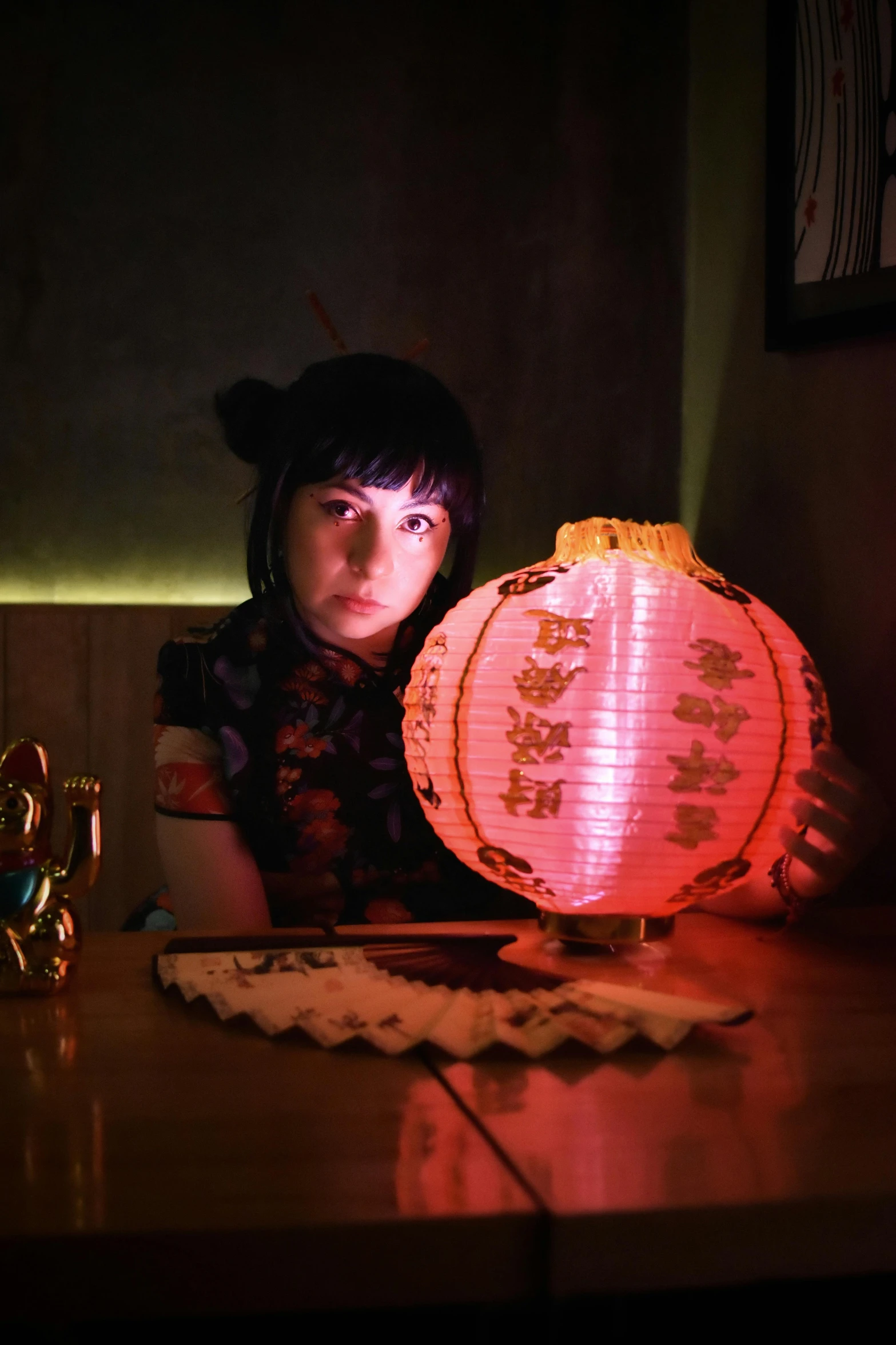 a woman is holding a chinese lantern lit by the light