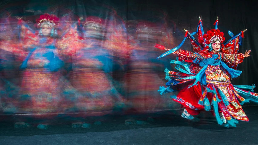 two dancers are holding up ribbons and masks