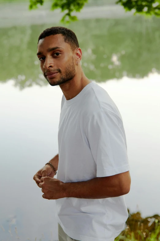 a man standing by the water staring at soing