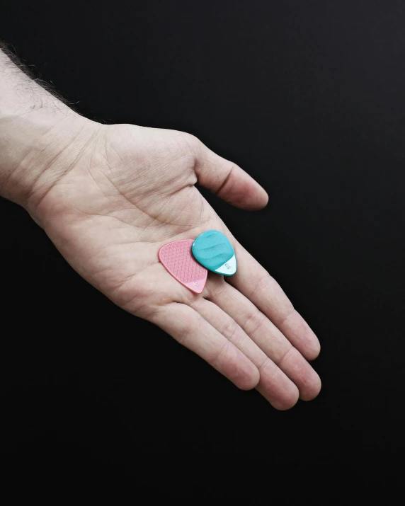 a small pink and turquoise heart shaped pin