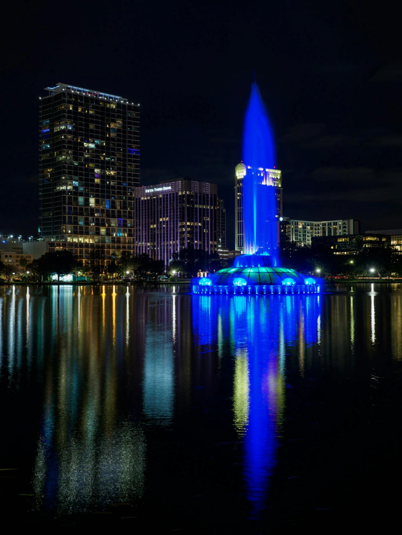 the city skyline is bright blue at night time