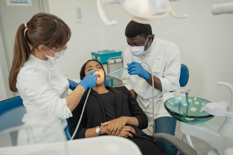 three young men and woman are at the dentist's office