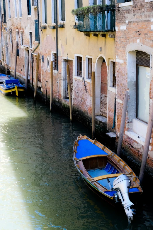 several small boats sit tied up in a canal