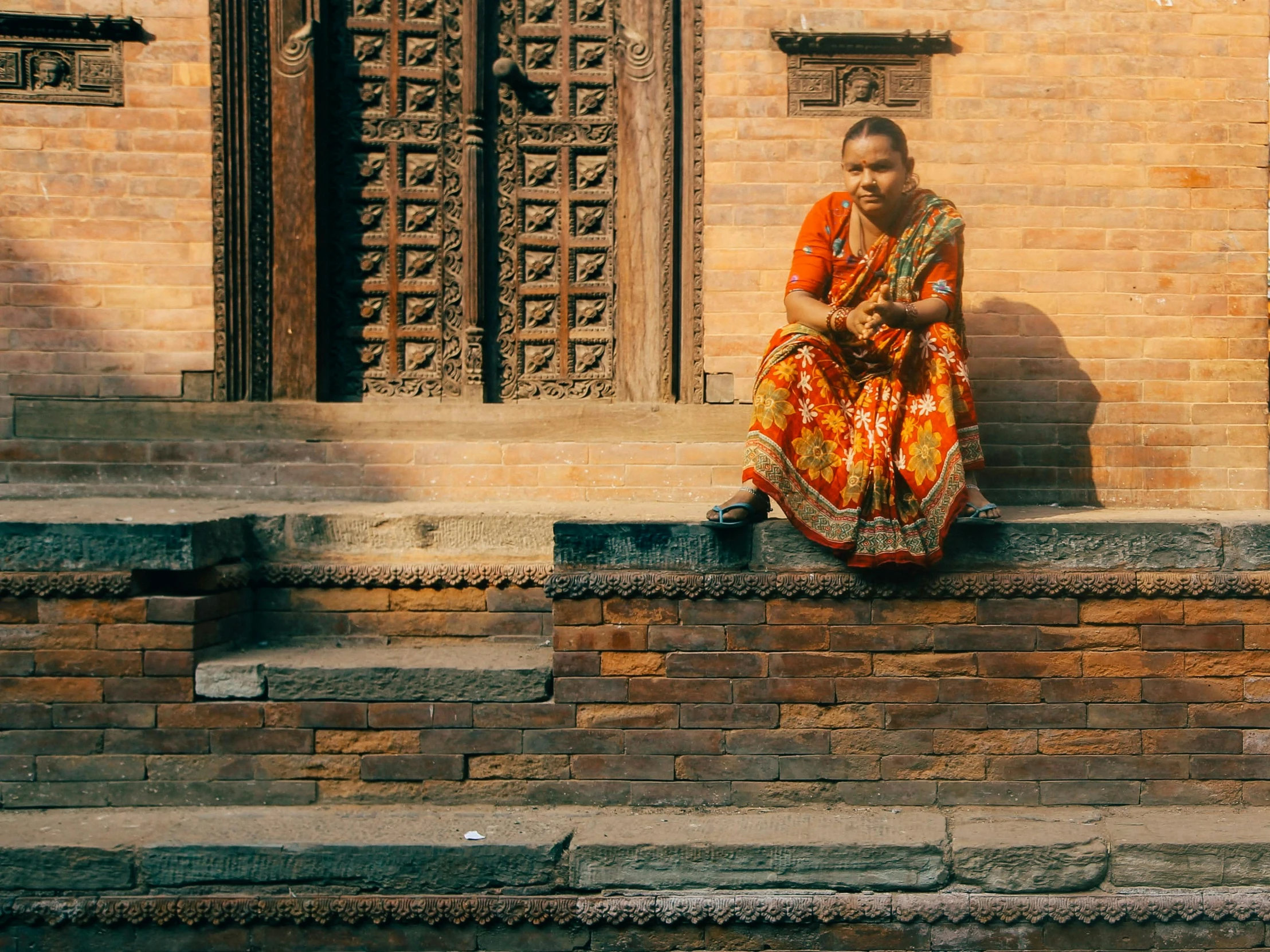 a woman sitting on the side of a building