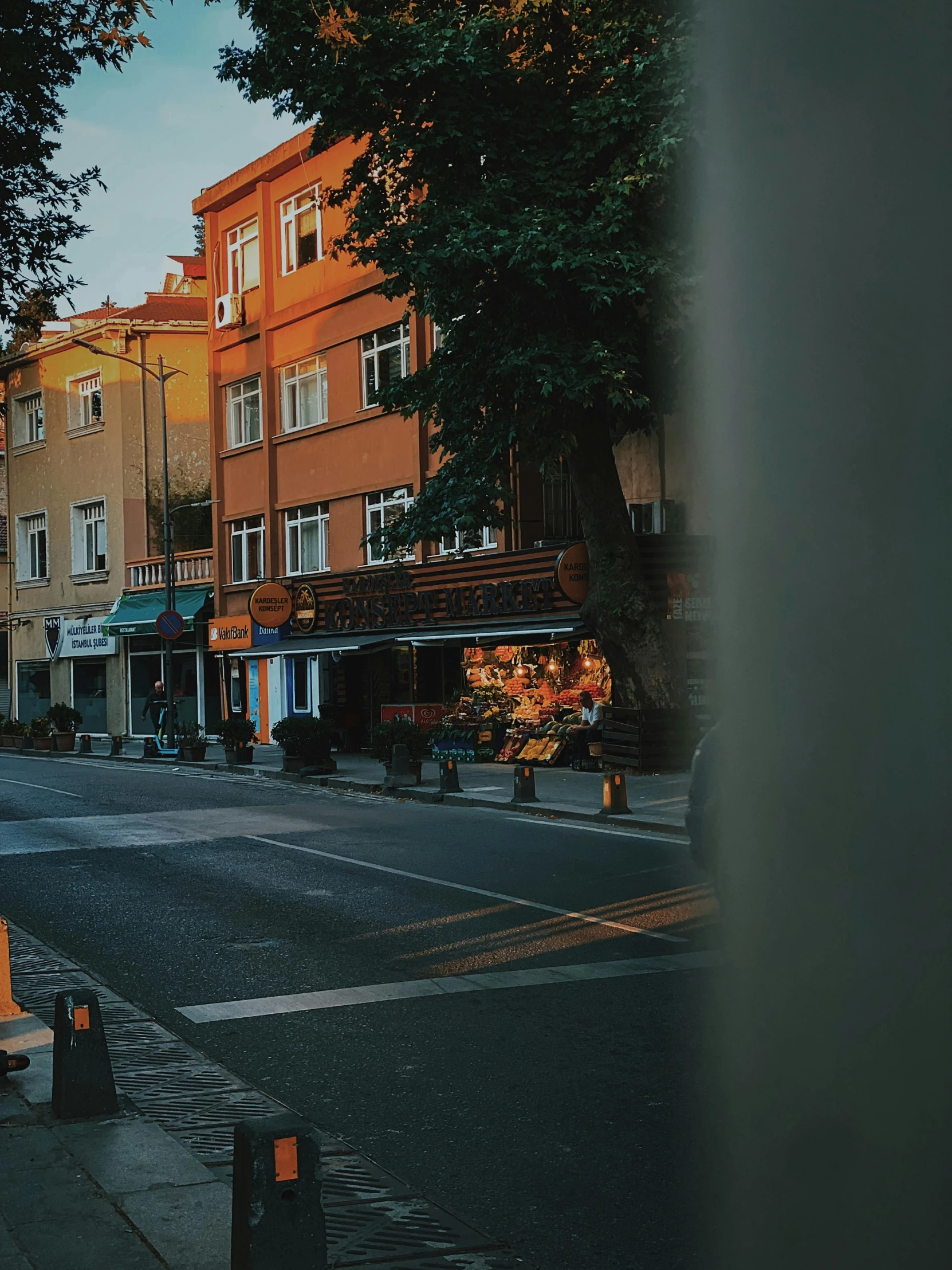 a narrow street has a building and benches lining the sides