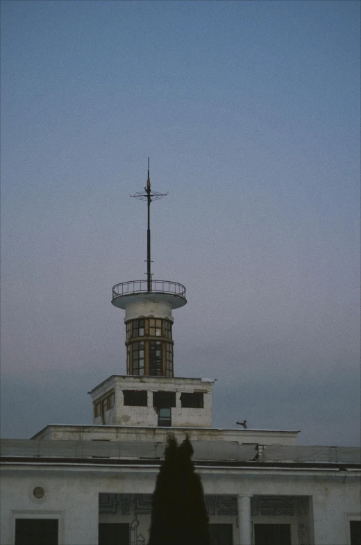 a view of a roof and its clock tower at dusk