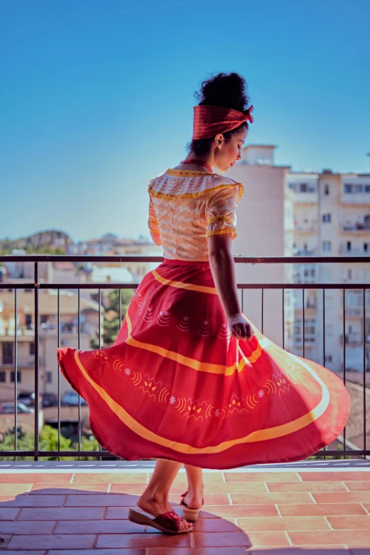 a woman in a long dress is walking on a balcony