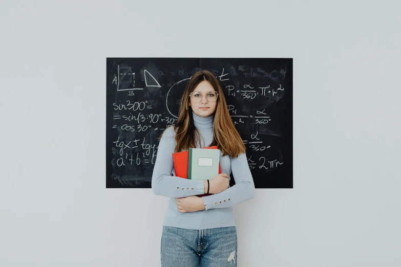 a person standing in front of a chalkboard with a laptop on top